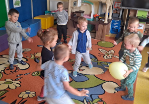 dzieci bawią się balonem na dywanie